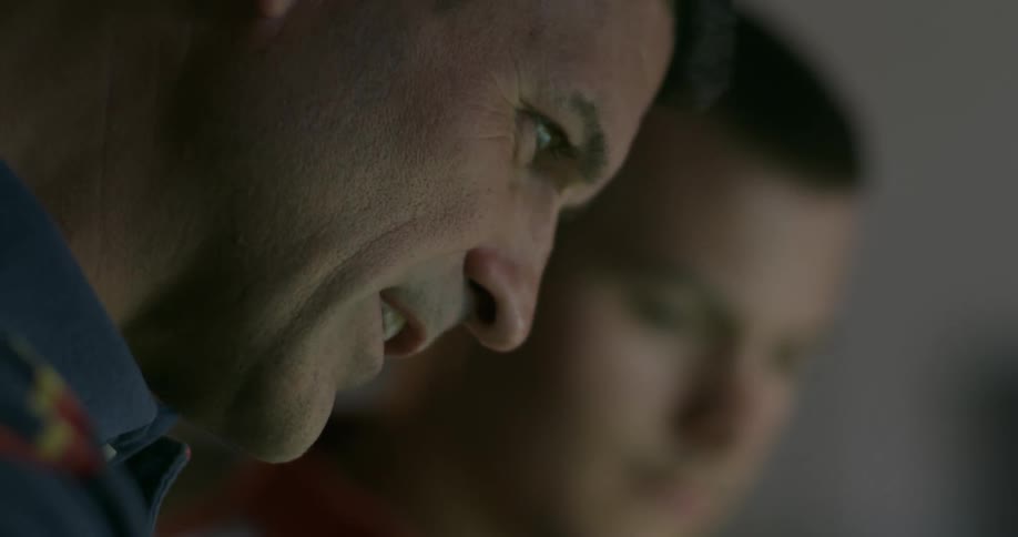 Two men looking down at something talking