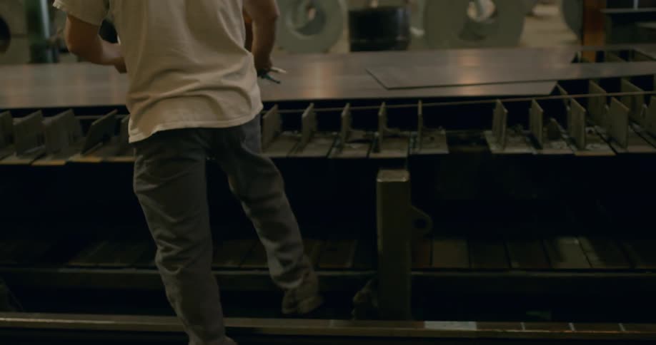 A man is examining a production line in a factory