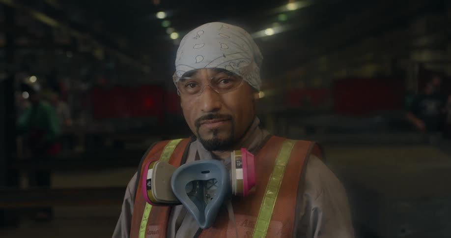 A man removes a mask in a factory