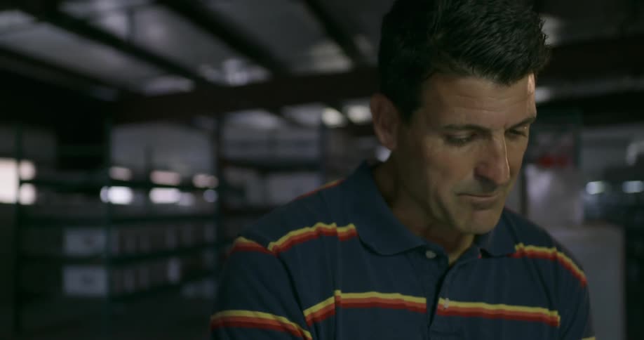 Man in a striped shirt talking in a warehouse