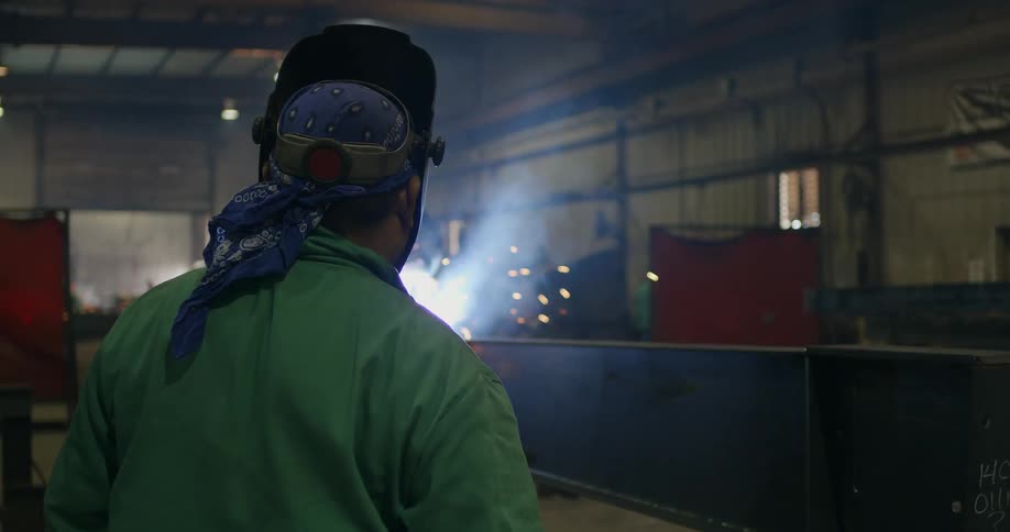 Welders in a workshop working with sparks flying