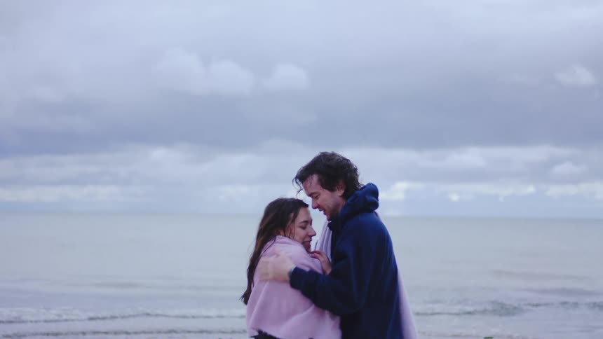 A man and woman hugging each other outdoors