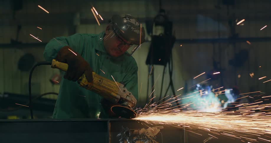 A man using a sanding machine with sparks flying