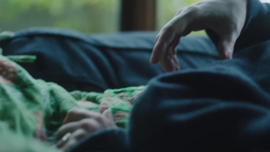Hands resting on patterned green blanket