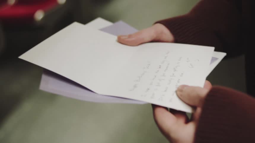 A man reading a card on a train