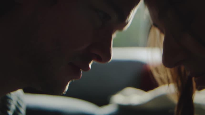 Couple touching foreheads in a closeup under soft light