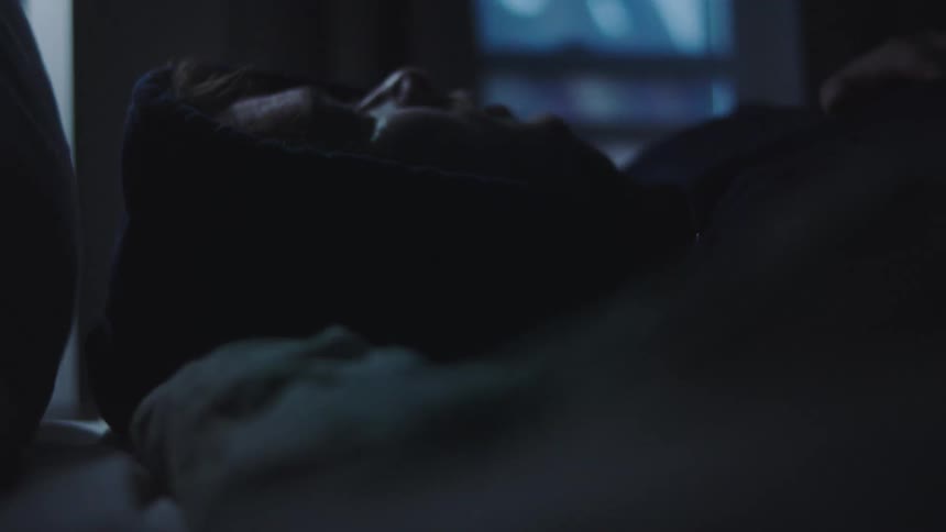 Man lying down turning off light in his face