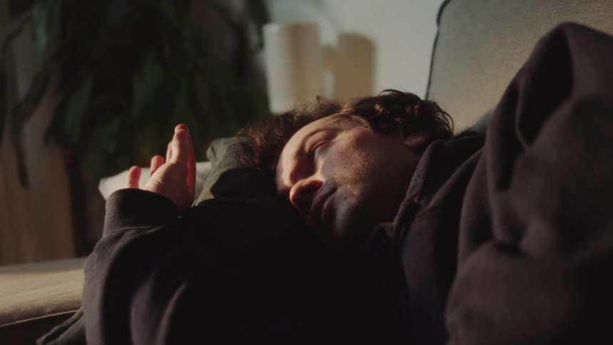 A man laying on a couch resting