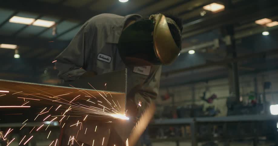 Sparks fly while a welder works in a factory