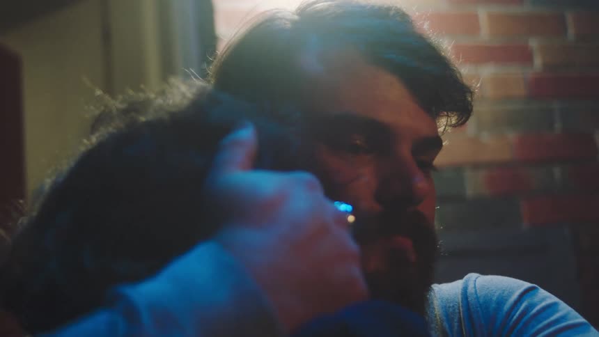 Two men hugging each other outdoors at night