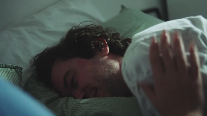 Man is lying down and talking to someone next to him