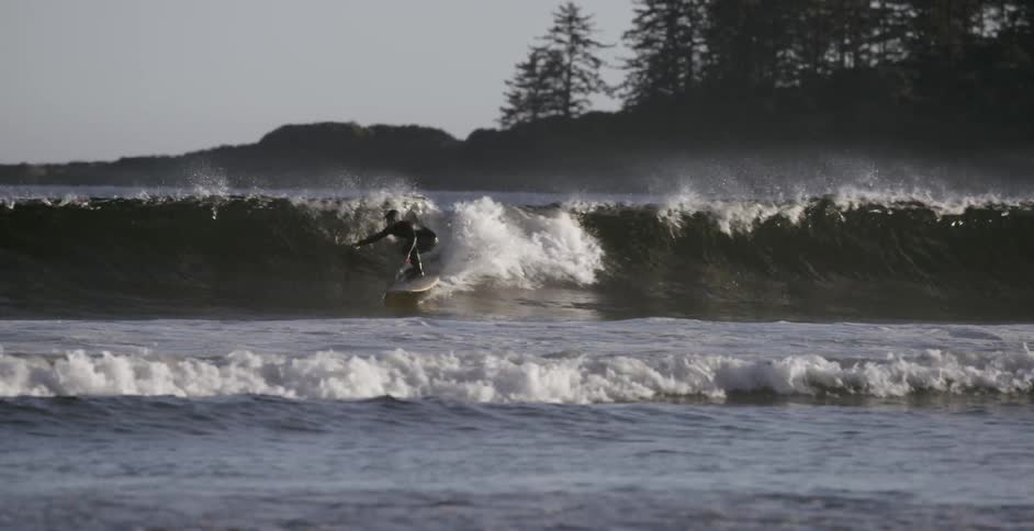 A woman rides a wave on a surfboard