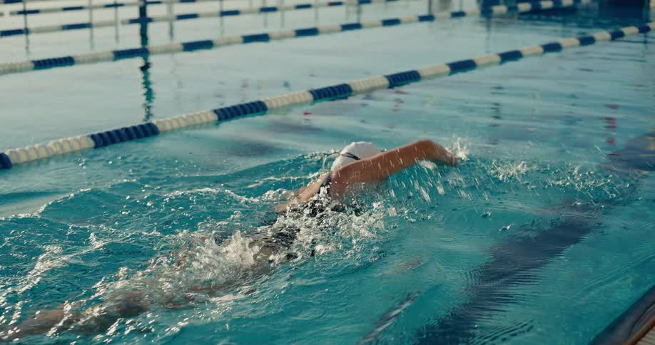 The woman is swimming fast in the pool