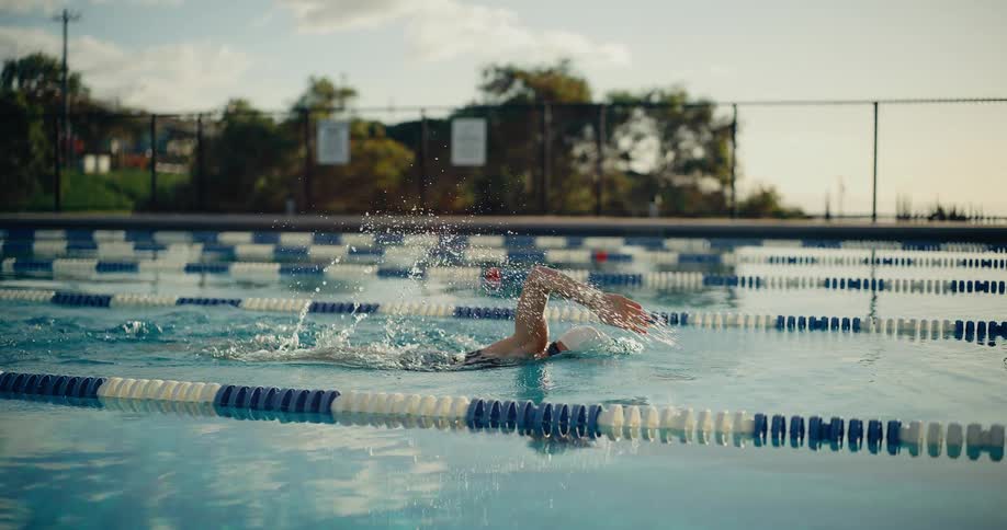 A woman swimming in a pool outdoors