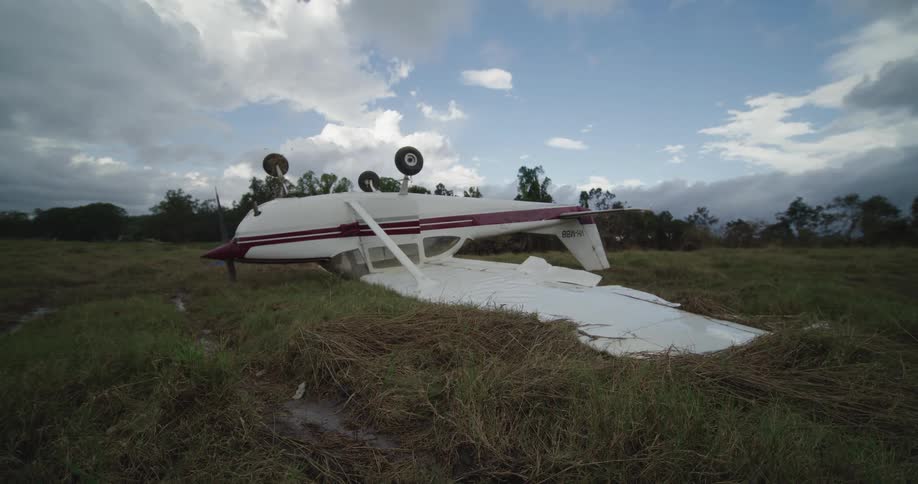Small airplane lying upside down in a field