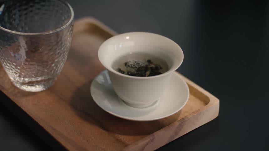 Close up of a person making tea in a white tea cup