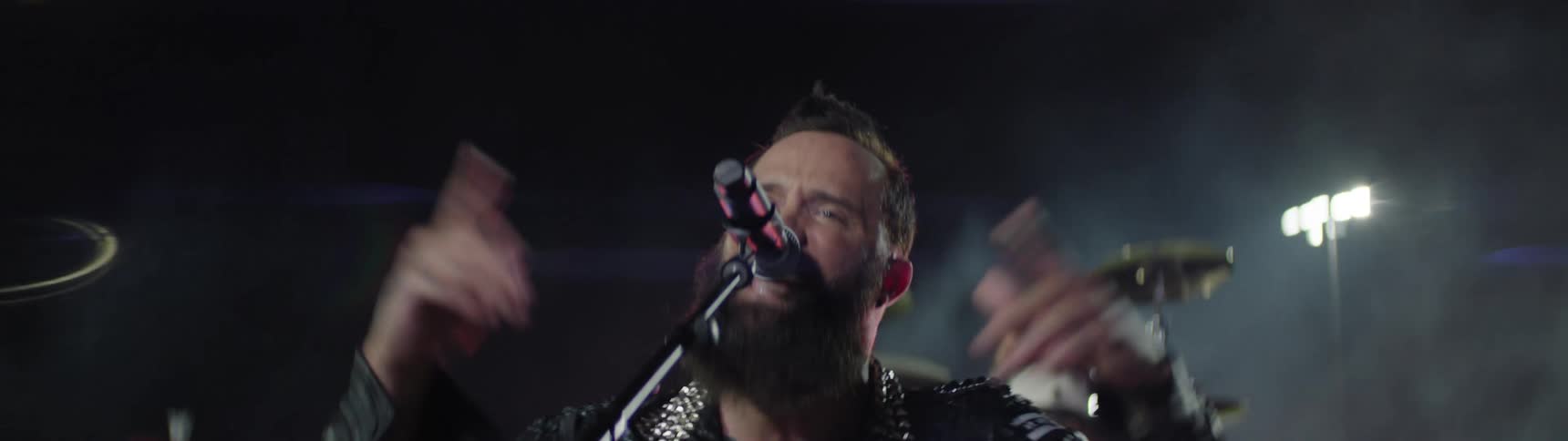 The singer is performing with a drummer behind him