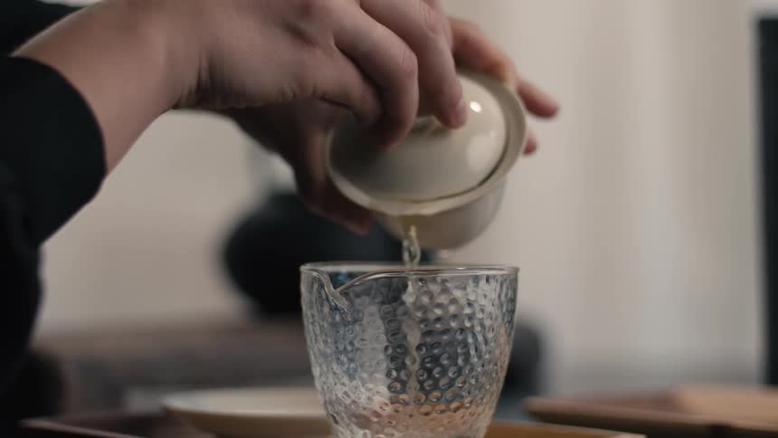 A person pouring tea into a cup