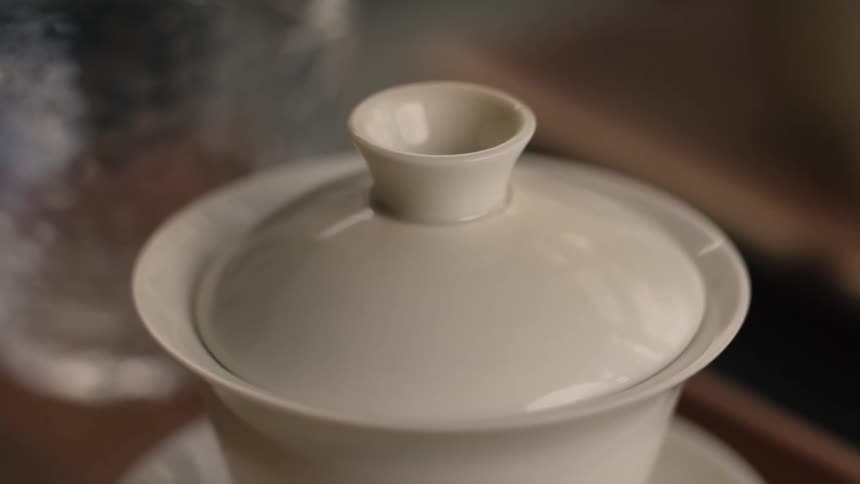 Lid is being placed on the white cup containing the dark bubbling liquid