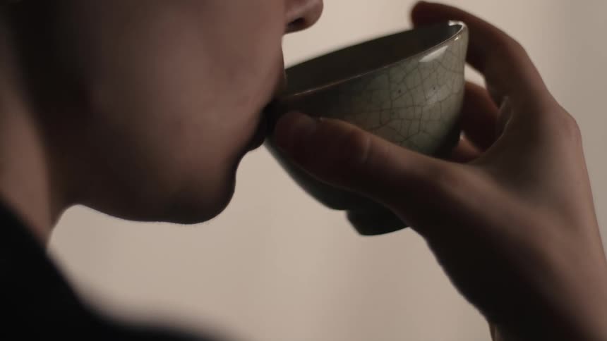 A young woman drinks from a teacup