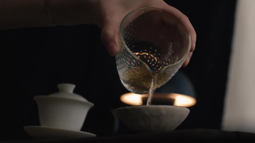 A person pouring tea into a bowl