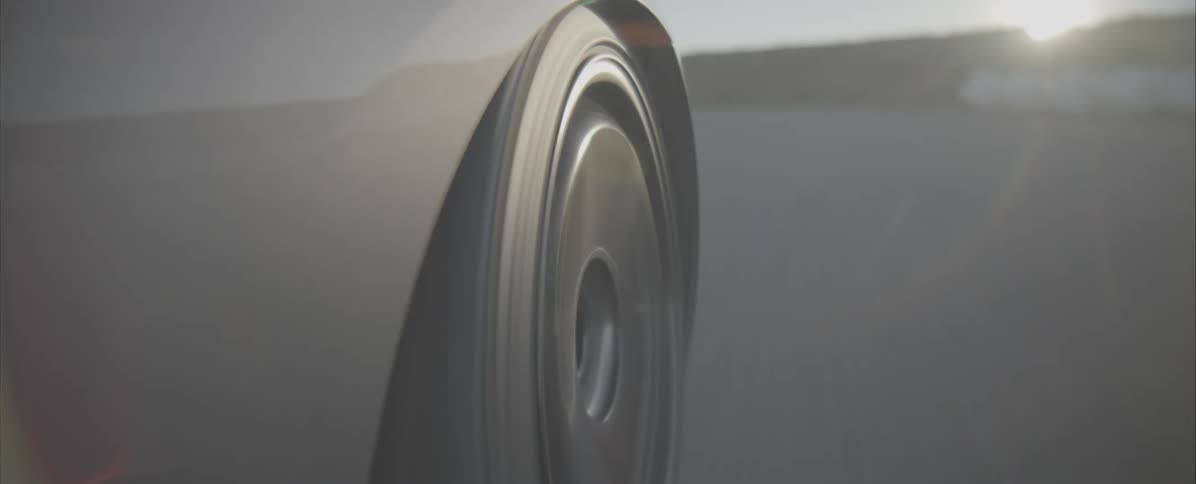 The camera is at the tire level of the car and filming the tire going around the track
