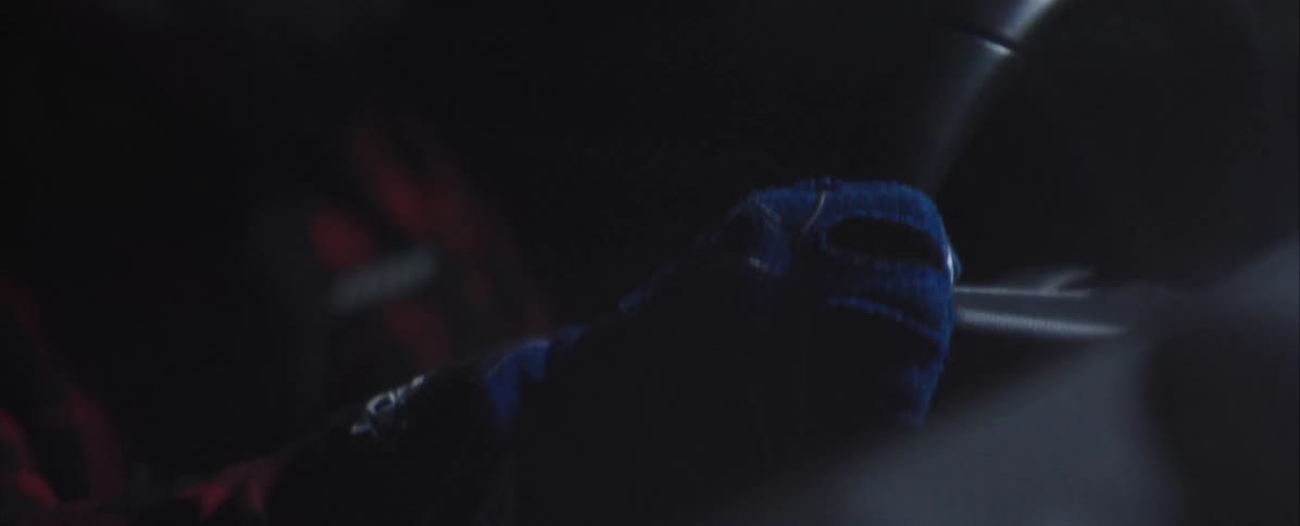 Hand gripping a steering wheel under low lighting inside a vehicle