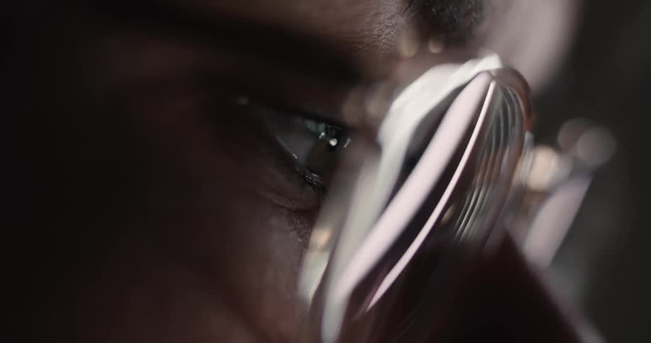 Eye with transparent glasses reflecting light in closeup frame focused on eyebrow