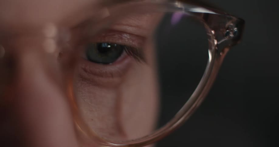 A close up of a persons face through a pair of glasses