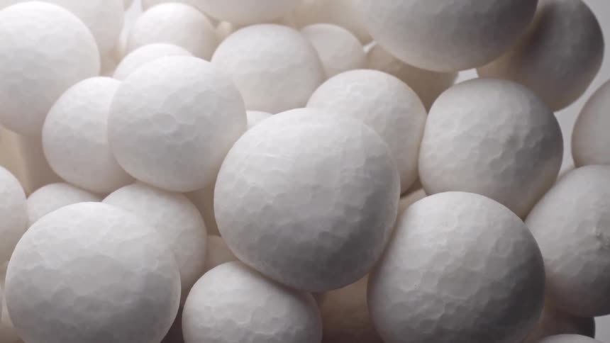 An overhead camera slowly pulls back from a cluster of pristine white mushrooms revealing the intricate texture of their tightly packed spherical caps