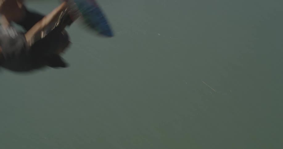 Man being pulled by a cable while wakeboarding on the lake