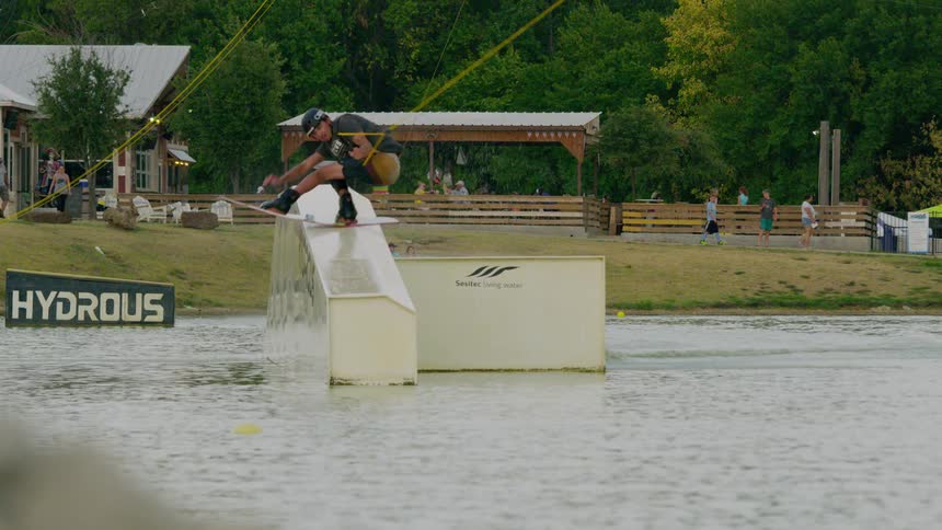 Wakeboarder performing a trick on an inclined module at hydrous park