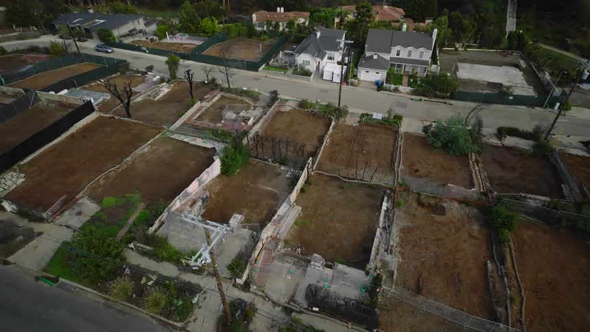 Series of empty lots with remaining foundations aligned in a residential area