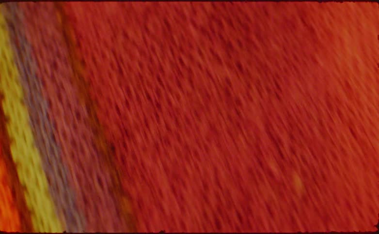 A closeup of a woven piece of fabric which has colorful stripes