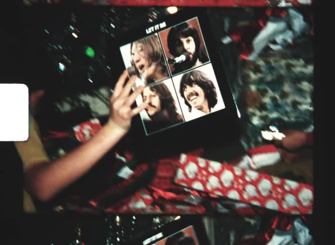 A child unwrapping a record at christmas