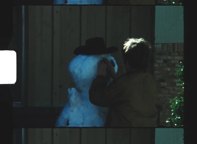 A child building a snowman outdoors
