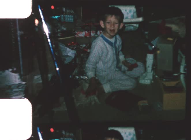 A male child playing with toys and presents in a garage