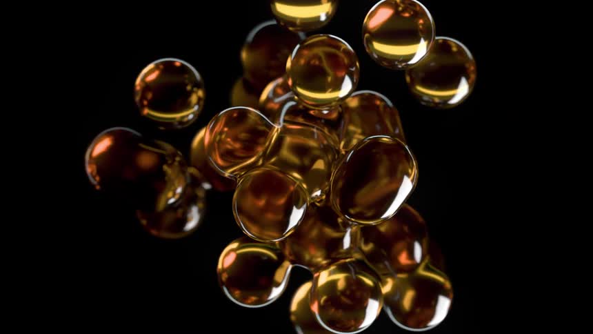 This is an abstract digital animation featuring shiny gold or ambercolored metallic spheres suspended in a dark space the spheres merge and separate fluidly resembling the movement of viscous liquid or ferrofluid with bright reflections suggesting hi