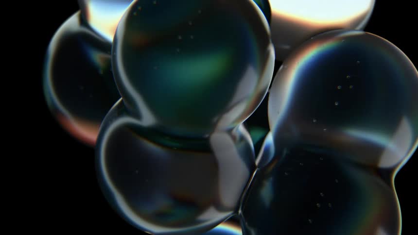 Iridescent glass like bubbles float and merge fluidly against a black background