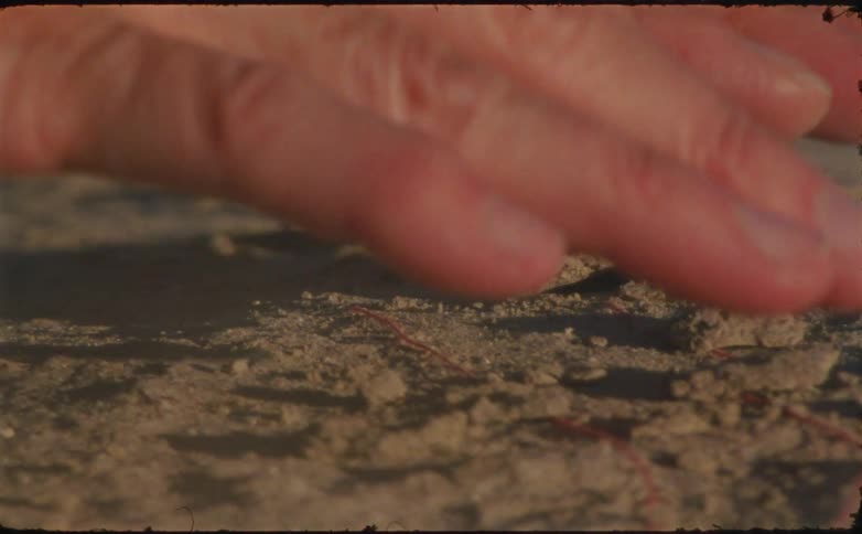 Hand interacting with sand