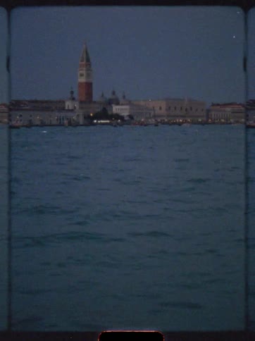 San giorgio maggiore bell tower stands illuminated above venices calm waters at twilight