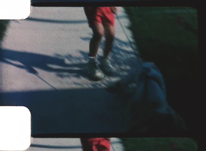 Child walking on a sidewalk holding an animal