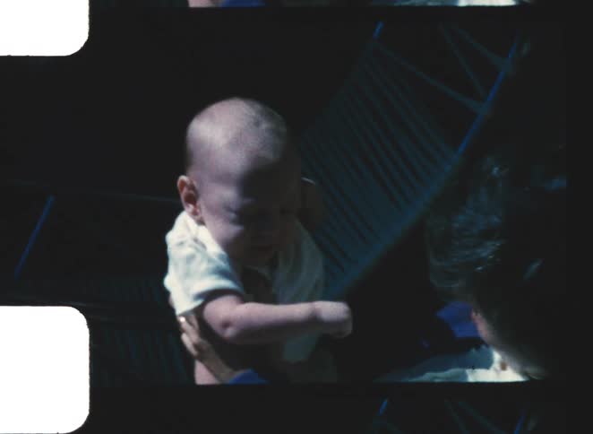 Woman holding a sleeping baby in her arms in an indoor setting