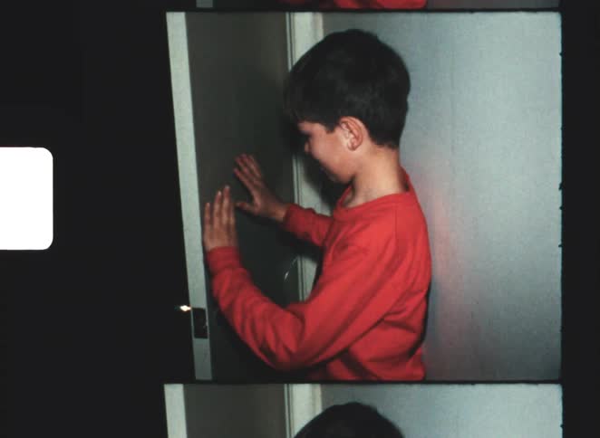 The boy lets his mother through the door
