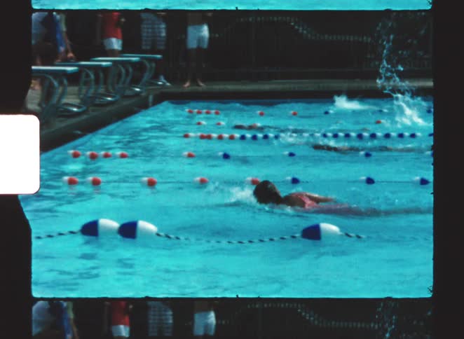 A group of swimmers compete in a swimming race