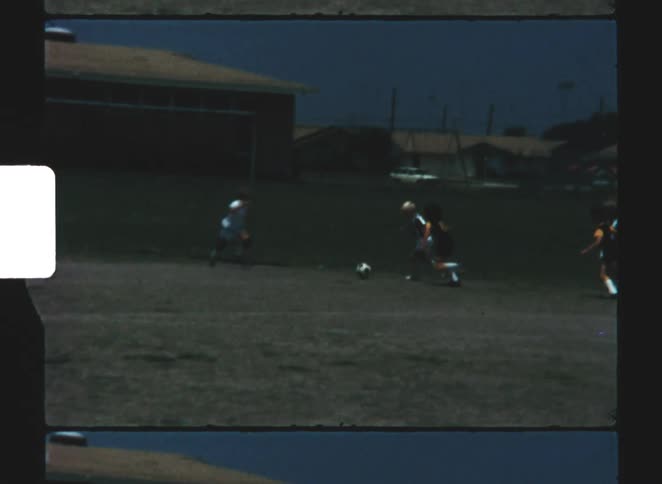 A group of kids playing soccer outdoors