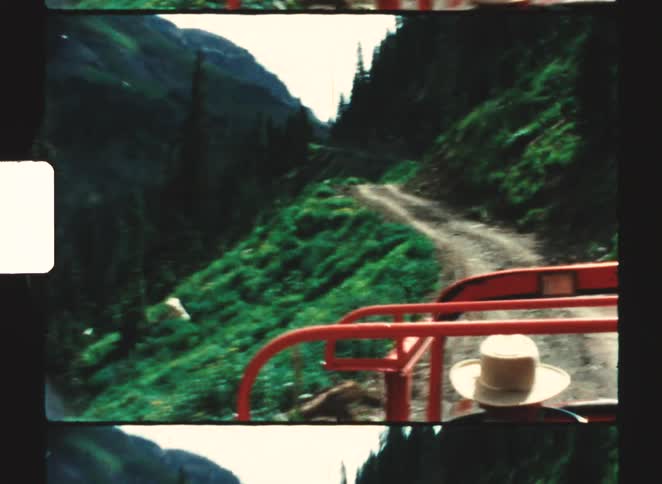 The vehicle is driving on the small mountain trail
