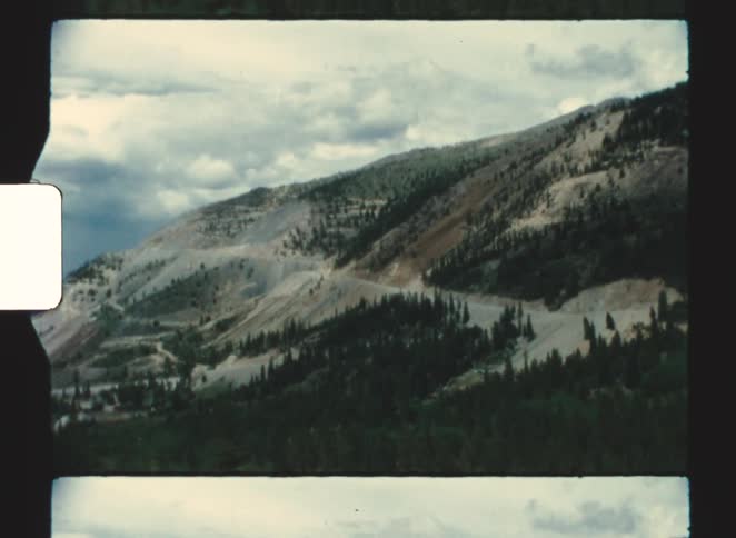 A mountainous range covered in green vegetation at midday