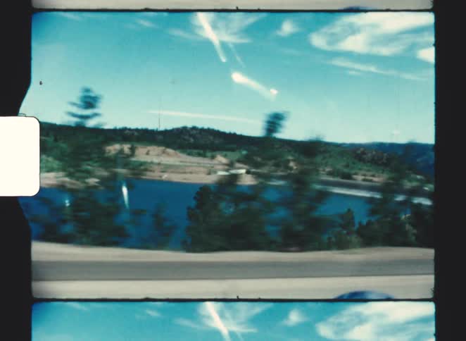 The car passes the large lake