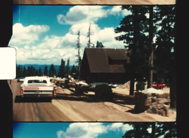 A view of cars driving in a rural dirt road